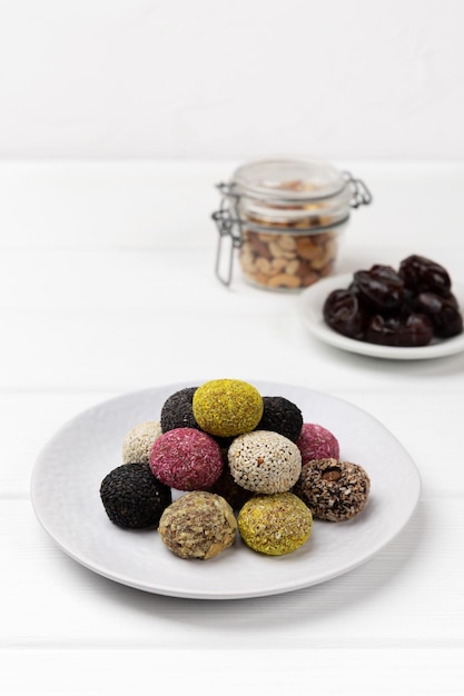 Colorful vegan candies energy balls on a plate on a white table