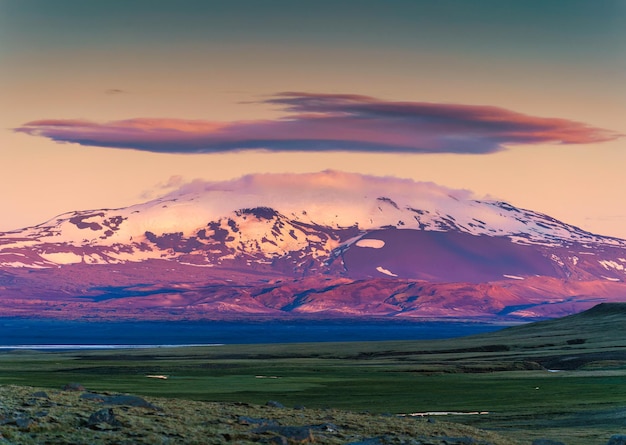 Montagna vulcanica colorata con nuvola di cappuccio tra gli altopiani islandesi in estate in islanda