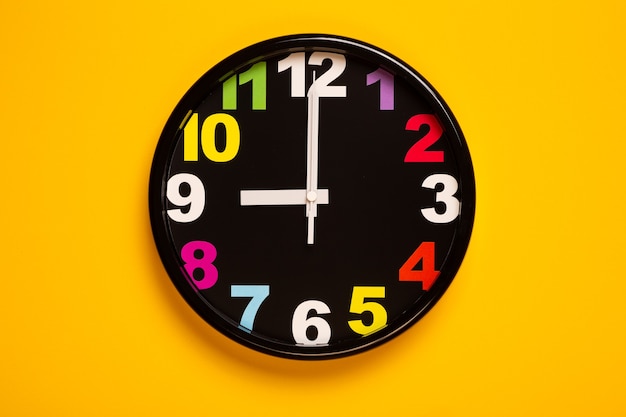 красочные настенные часы показывают девять часов