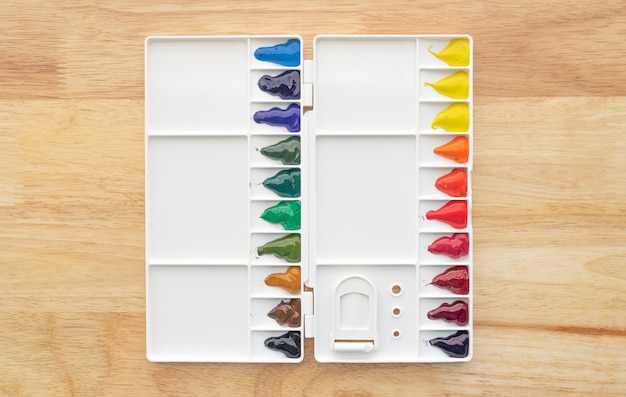 Photo colorful watercolor paints set in watercolor palette on wood. bright multicolored aquarelle paints in paint box.