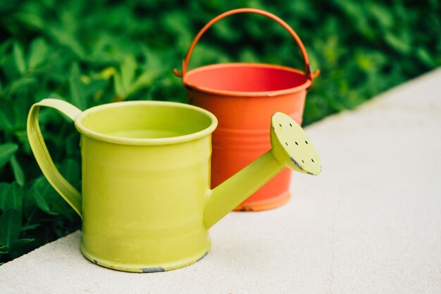 Colorful watering cans and buckets for plants in garden