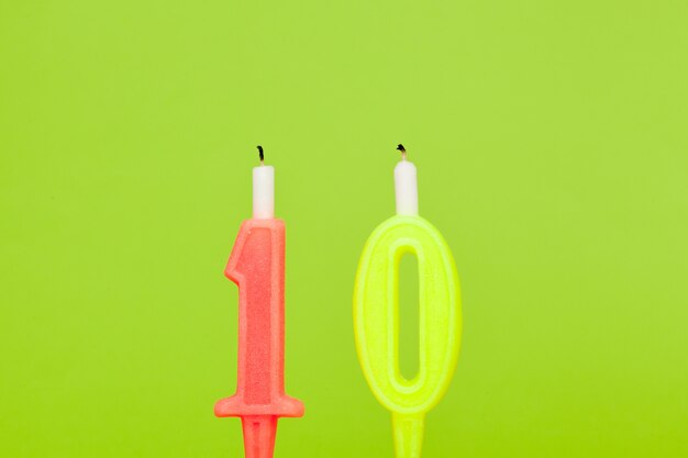 Colorful wax birthday candle  on green