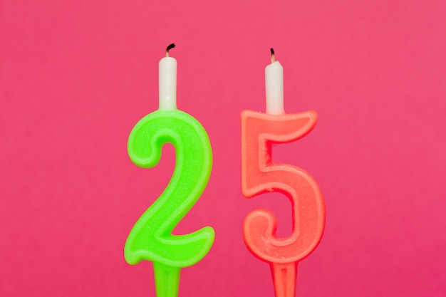 Colorful wax birthday candle  on pink background