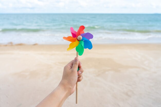 Colorful windmill paper embroidered on the beach Sea view in the daytime 