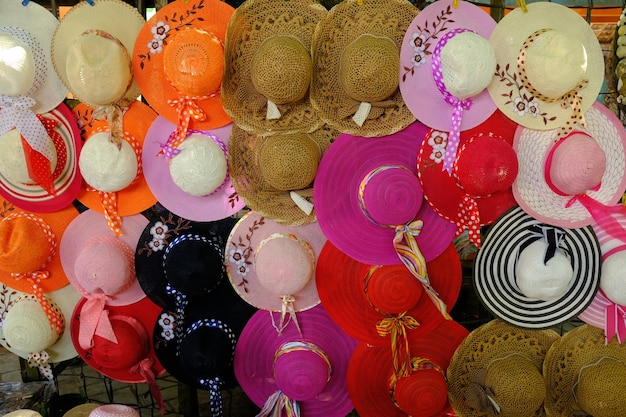 colorful women's hats hanging on display. woven rope hats, thread woven hats, knitted hats. red.