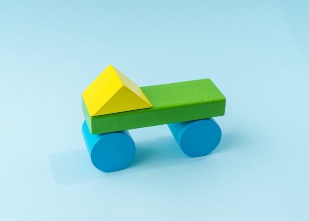 Colorful wooden block toy on light blue background.