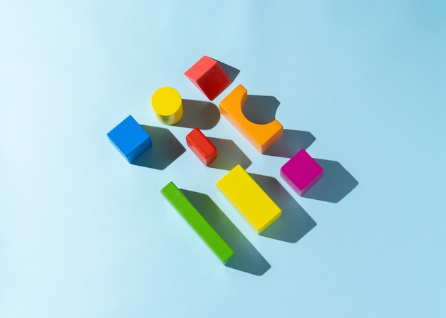 Foto giocattolo di blocco di legno colorato su sfondo azzurro.