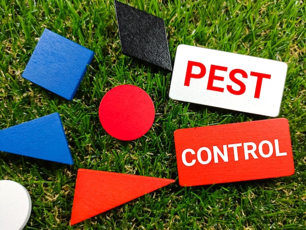 잔디 배경에 PEST CONTROL이라는 텍스트가 있는 다채로운 나무 보드