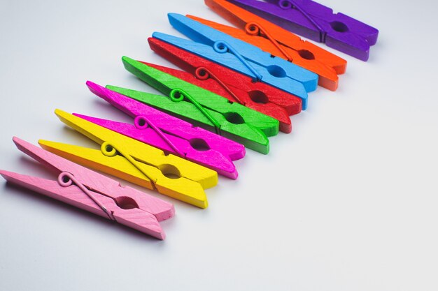 Colorful wooden clothespins on white background. close up, copy space.