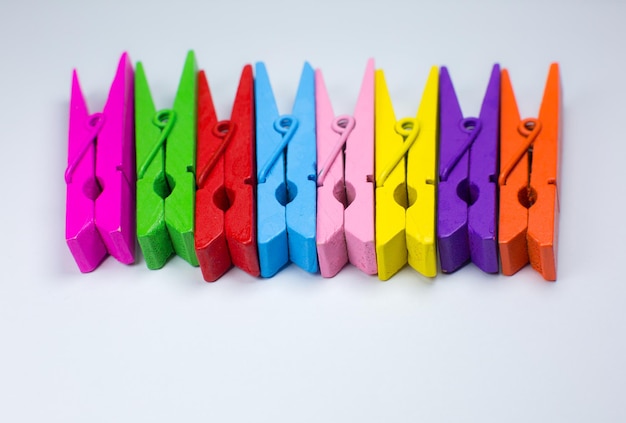 Colorful wooden clothespins on white background. Close up, copy space.