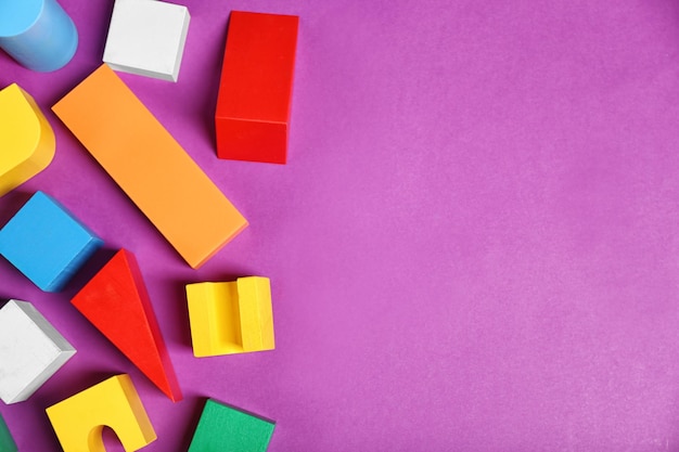 Colorful wooden kids toys on purple background