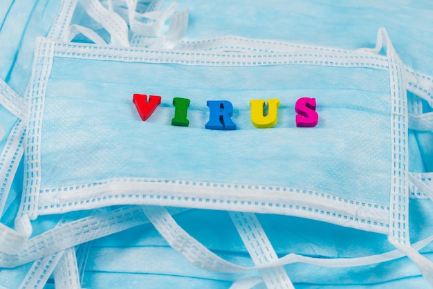 Colorful word virus on protective masks. Top view.