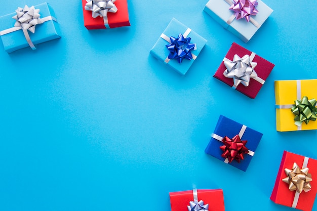 Colorful wrapped gift boxes with bow on blue background