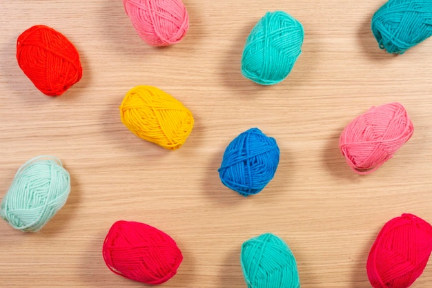 Colorful yarn for knitting on wooden background