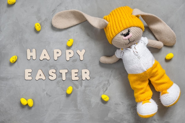 Colorful yellow Easter eggs bunny toy and text happy easter