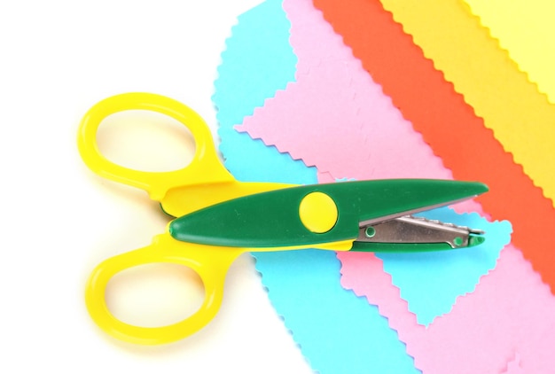 Фото Красочные зигзагообразные ножницы с цветной бумагой, изолированной на белом