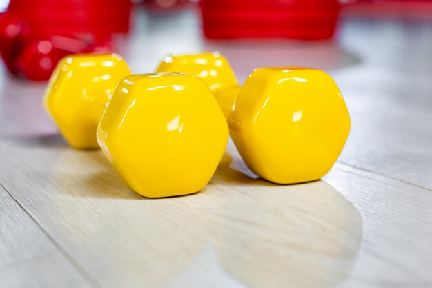 Colorfull modern dumbbells in the foreground on a wooden white floor