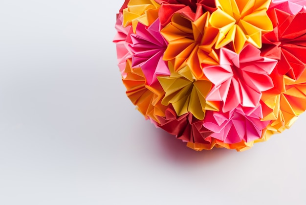 Colorfull origami kusudama from rainbow flowers on white. Warm colours