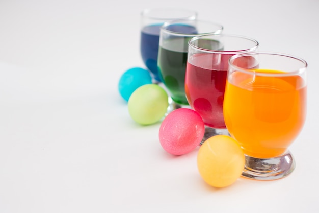 Photo coloring eggs with colored liquid dyes in a glass goblet.