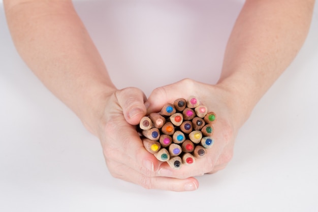 Coloring pencils bunch in hands shot on  white top view
