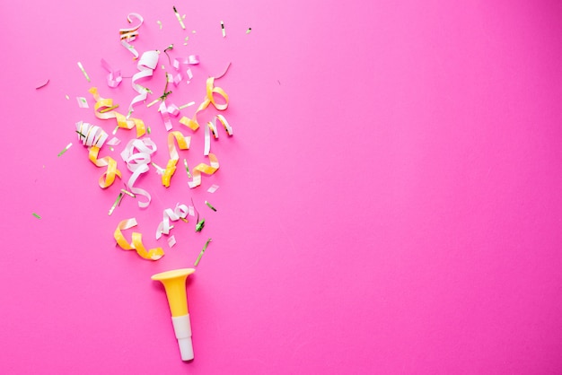 Colorul party streamers on pink background.