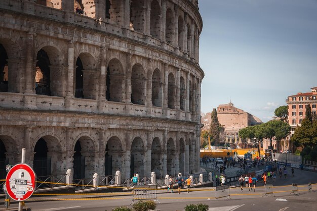 Foto colosseum in rome italië onder heldere lucht met hardlopers