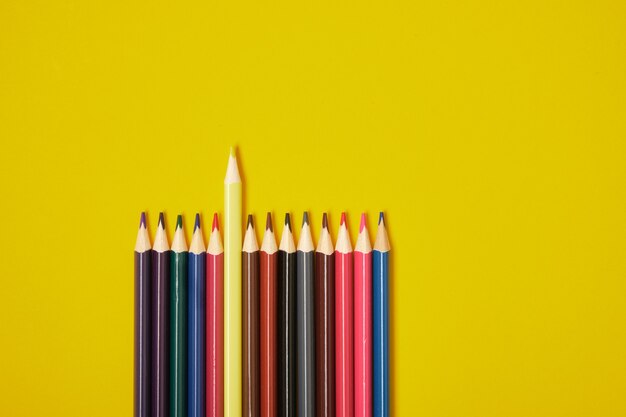 colour pencils on a yellow background with copy space