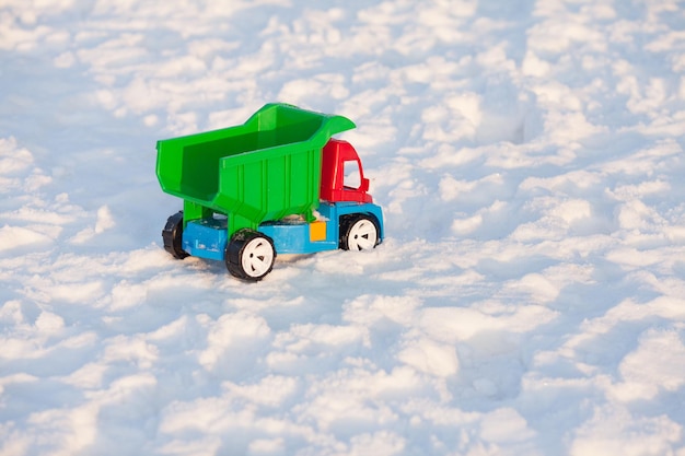 雪の上の色のおもちゃのトラック。ベッドの天候と除雪に関するコンセプト