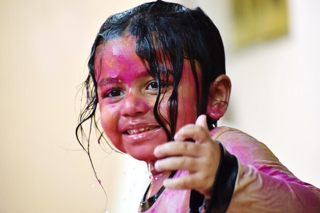 Coloured face of a cute baby at the time of holi a festival of colours
