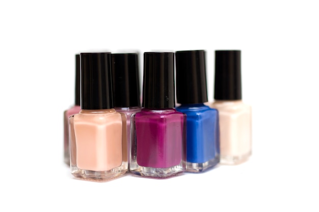 Coloured nail polish bottles on a white background