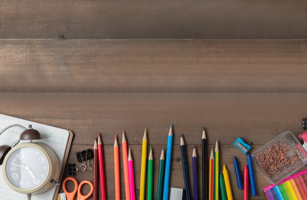 coloured pencil with alarm clock and stationary 