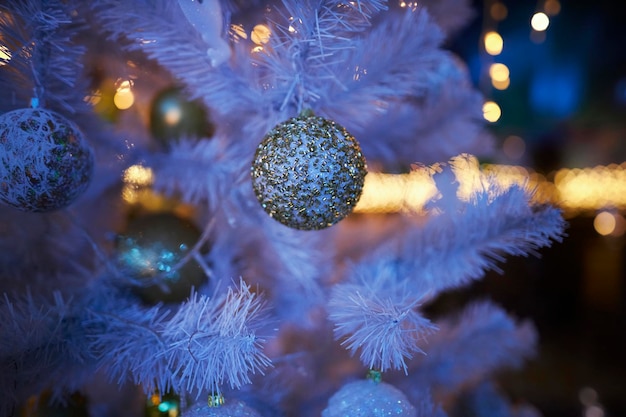 Colourful christmas decorations hanging from white christmas tree. white Christmas tree.