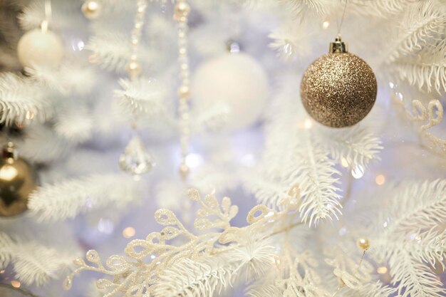 Colourful christmas decorations hanging from white christmas tree. white Christmas tree.