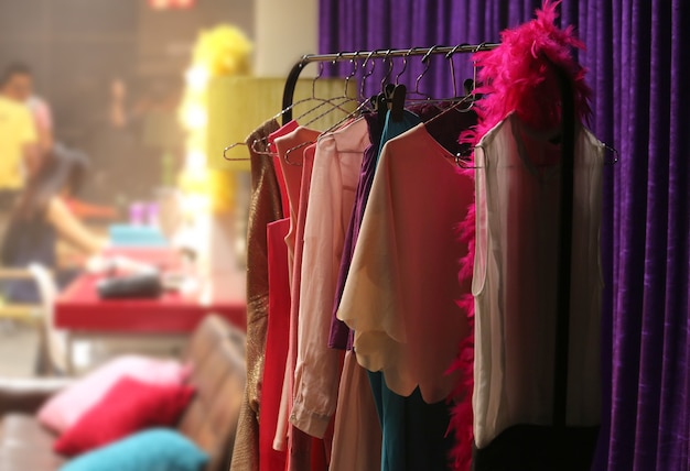 the colourful clothes rack in a backstage room of fashion show