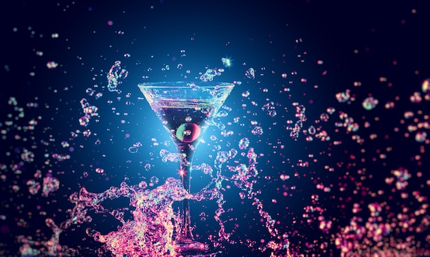 Colourful cocktail in glass with splash on the dark background