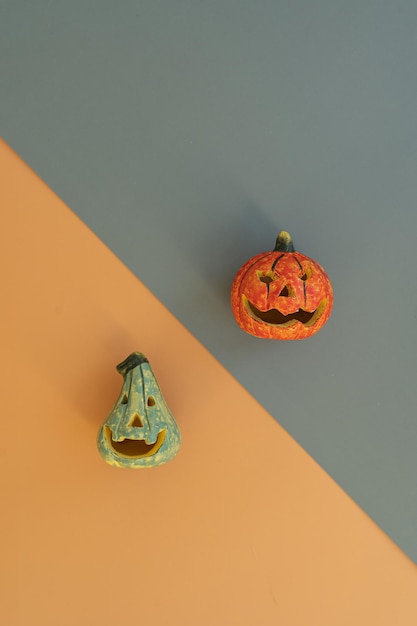 Colourful halloween pumpkins on orange and grey background with copy space Minimal autumn fall holidays concept