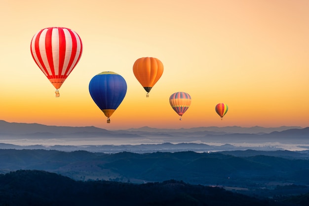 Photo colourful hot air balloons flying over the mountain