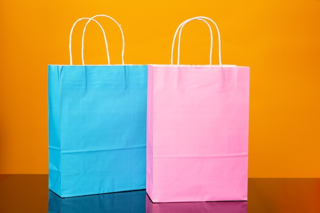 Colourful paper shopping bags on black glass table and yellow