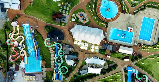 Colourful plastic slides in aquapark Sliders with pool Enjoying summer vacation in water park Aerial view of aqua park