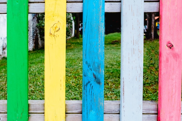 Colourful rows of painted wood on a playground fence