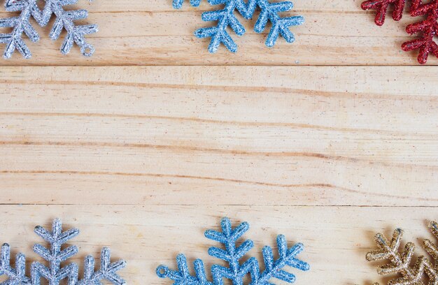 Photo colourful snowflakes frame on old wooden background with empty