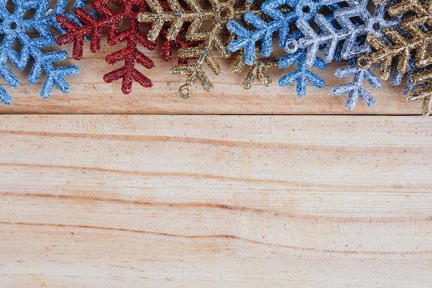 Photo colourful snowflakes on wooden background with copy space