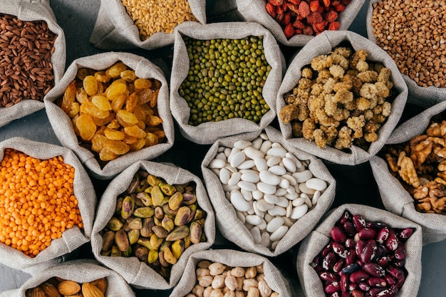 Colourful various beans in cloth sacks Uncooked assorted legumes Mulberry buckwheat pistache raisins almond garbanzo others Healthy cereals