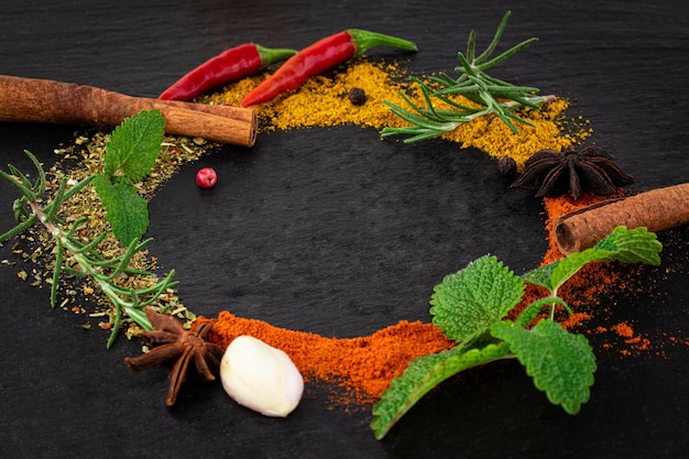 Colourful various herbs and spices on dark background.