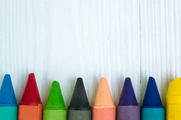 Colourful wax crayons pencils on white wood table