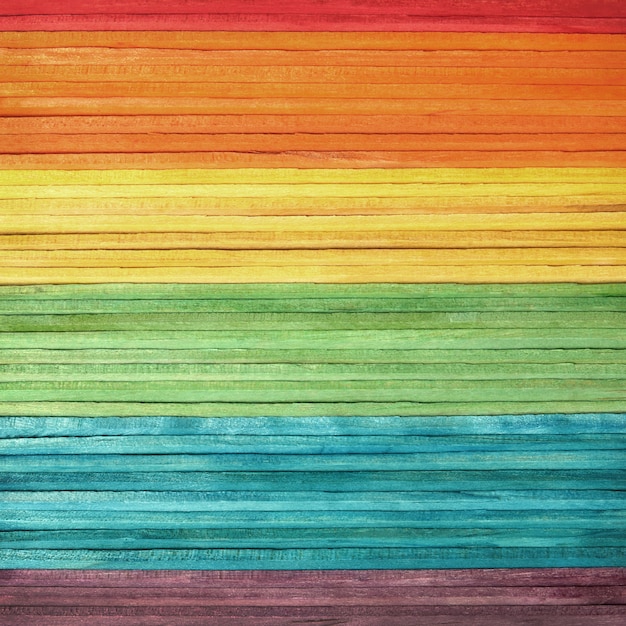 Colourful wooden wall texture in bright rainbow swatch pattern.