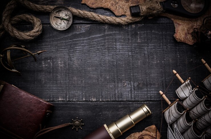 Columbus Day. Vintage worldmap and discovery equipment. Copy space on dark wood background.