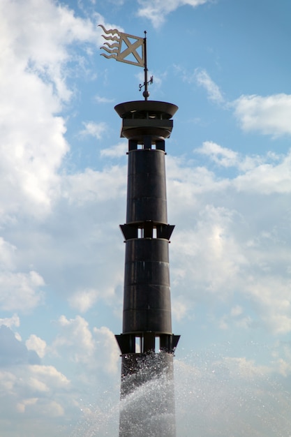 Column lighthouse on a background of blue sky in the park 