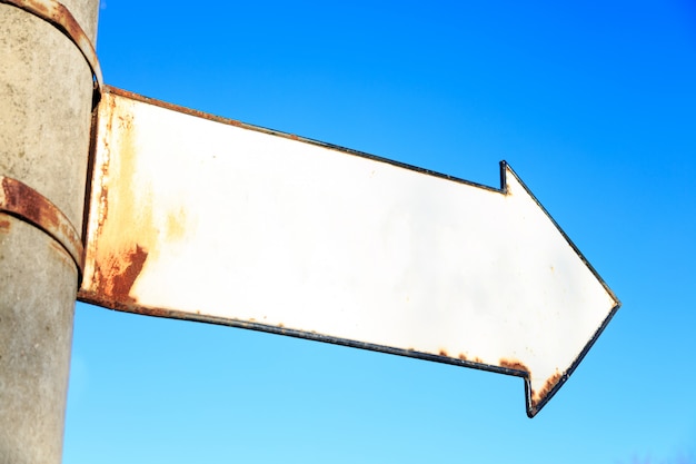 Photo column with rusty signpost in arrow shape