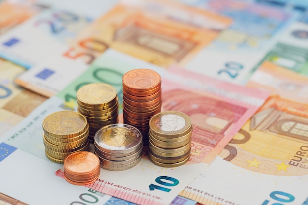 ユーロ硬貨の列は、ユーロ紙幣のクローズアップ。経済学と金融の概念。